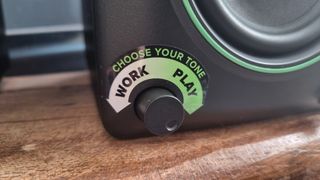 The tone adjustment dial of a Mackie CR3.5 BT speaker, with a sticker above it indicating the "work" and "play" settings