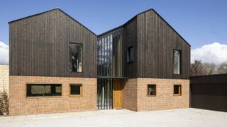 dark stained vertical timber cladding on contemporary timber frame house