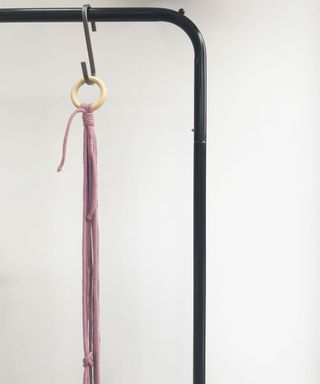purple cord hanging on s shaped hanger with wooden ring