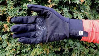 Underside of off-road cycling gloves in front of a hedge