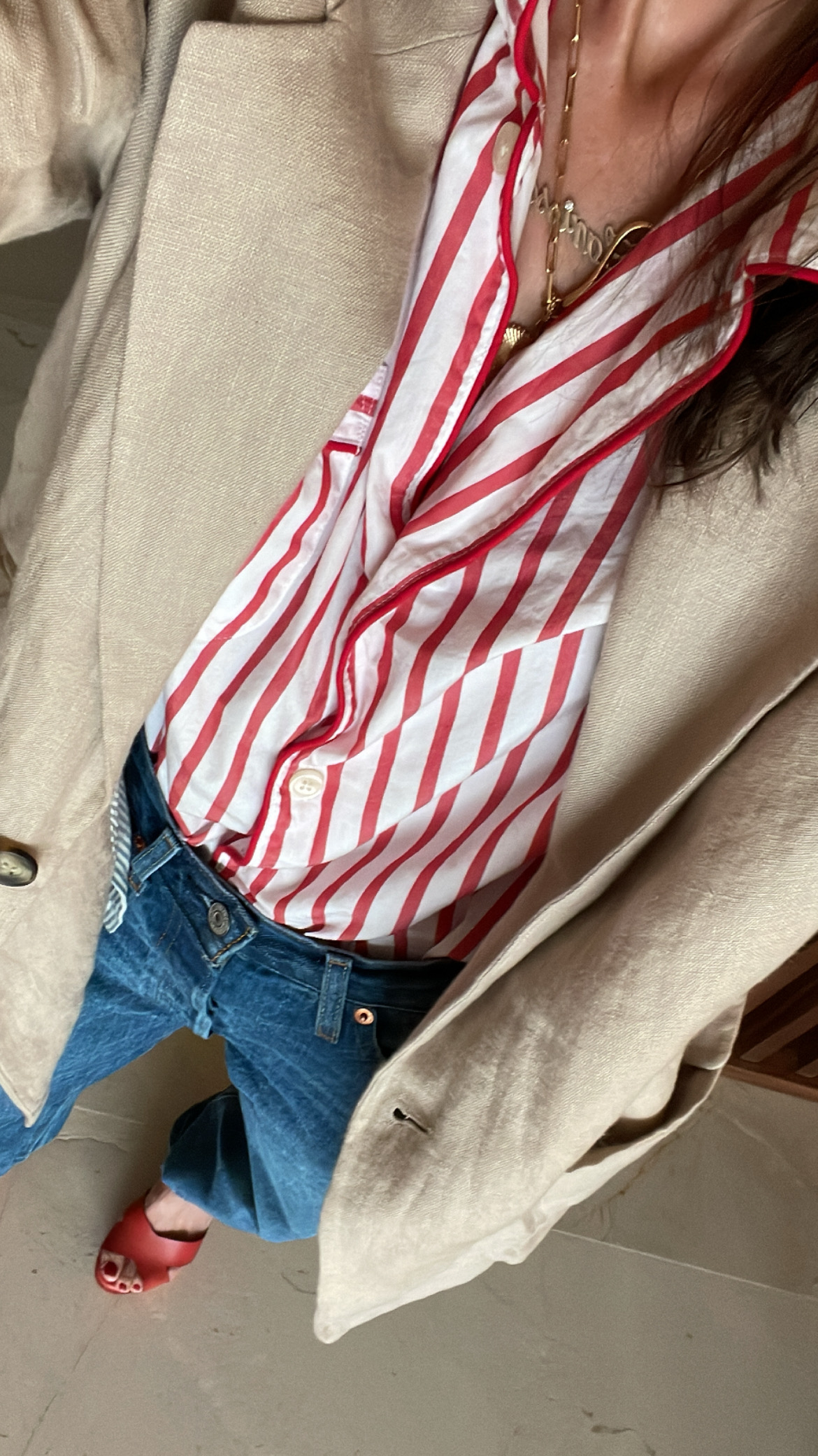 Larissa Mills wearing a red and white striped pajamas shirt, jeans, and tan blazer