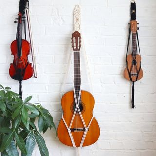 Three Macra Music instrument hangers on a white wall