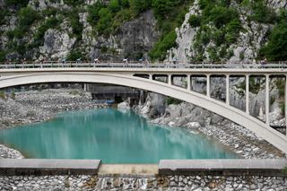 MONTE ZONCOLAN ITALY MAY 22 The Peloton passing through Ravedis Bridge in Maniago Village 283m during the 104th Giro dItalia 2021 Stage 14 a 205km stage from Cittadella to Monte Zoncolan 1730m Landscape UCIworldtour girodiitalia Giro on May 22 2021 in Monte Zoncolan Italy Photo by Tim de WaeleGetty Images