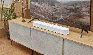 The Sonos Beam gen 2 soundbar in white on a wooden TV stand