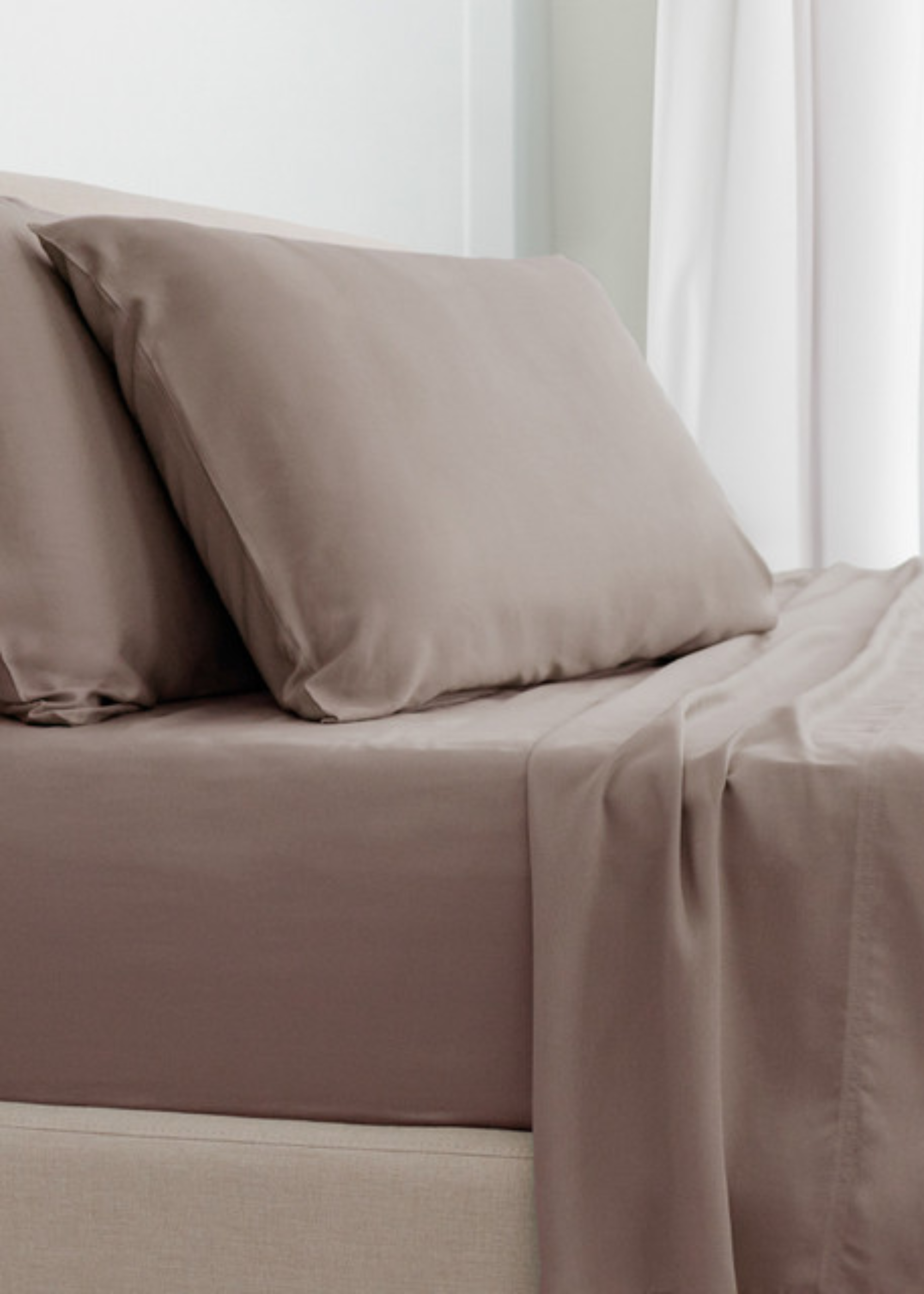 A minimalist bedroom with light brown bamboo bedding