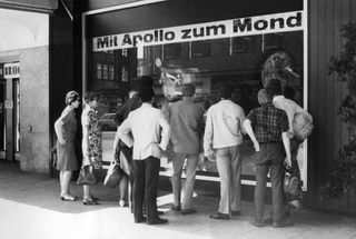 People in front of a TV shop in Germany watch the launch