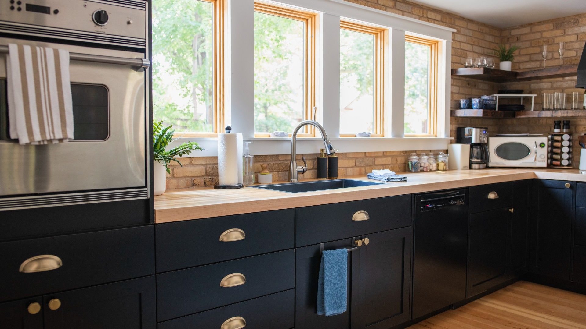 View of home kitchen showing oven and counter top with daylight shining through windows