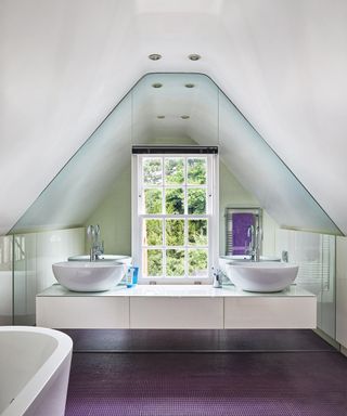 A bathroom with a large mirrored wall behind a double vanity