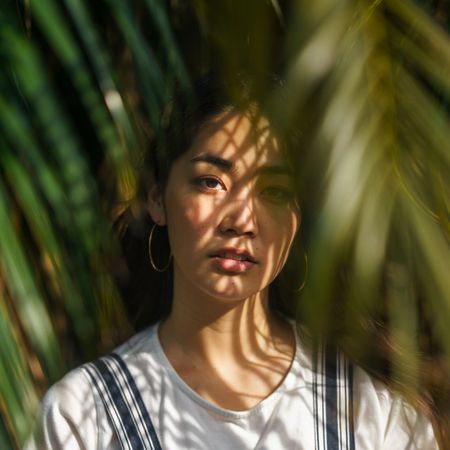 woman with sun on her face surrounded by trees