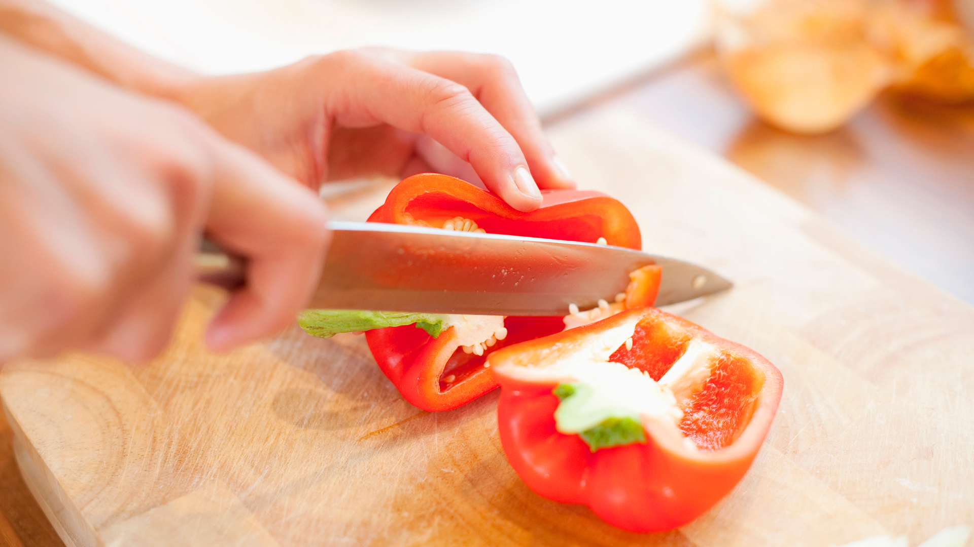 Close up of Caucasian woman slicing red bell pepper