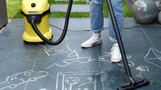 An outdoor vacuum cleans chalk on paving