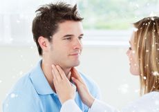 A doctor palpates a man's throat