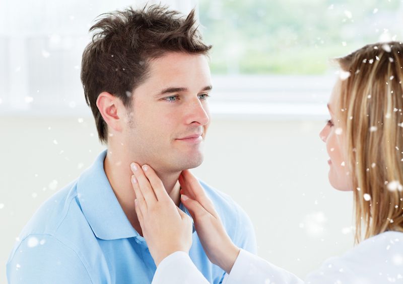 A doctor palpates a man&#039;s throat