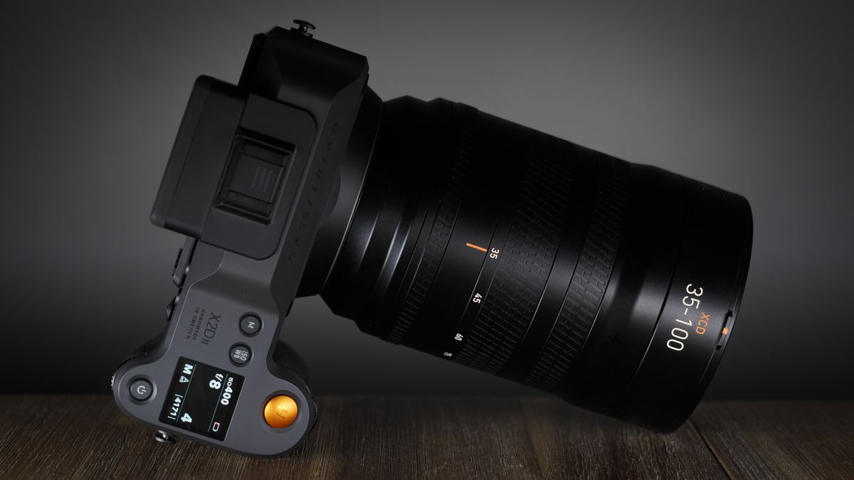 Hasselblad XCD 35-100E lens on a wooden surface in a moodily lit environment