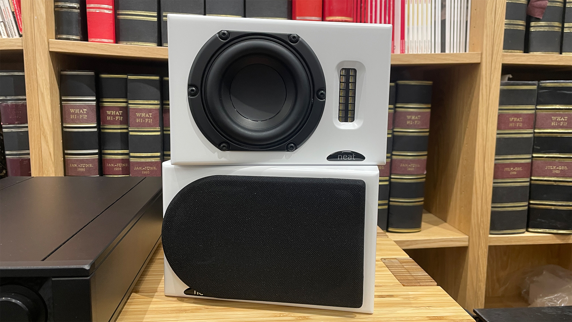 Neat Iota II speakers, with one with black grille on and one off showing the drivers