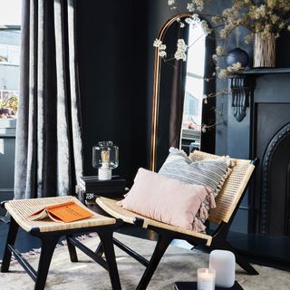living room with black wall and cane chair