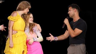 (L-R) Taylor Swift, Joey King and Taylor Lautner speak onstage for night one of Taylor Swift | The Eras Tour at GEHA Field at Arrowhead Stadium on July 07, 2023 in Kansas City, Missouri.