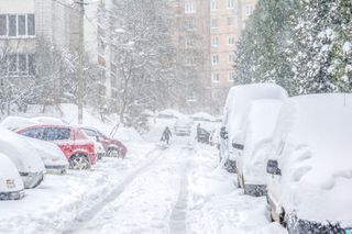 Cars covered in many feet of snow during a blizzard.