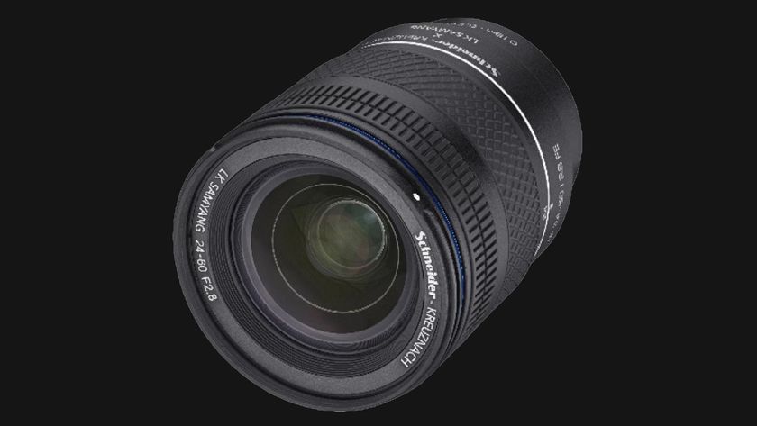 A close-up of a Samyang 24-60mm f/2.8 camera lens, featuring a textured grip and clear glass front, set against a dark background