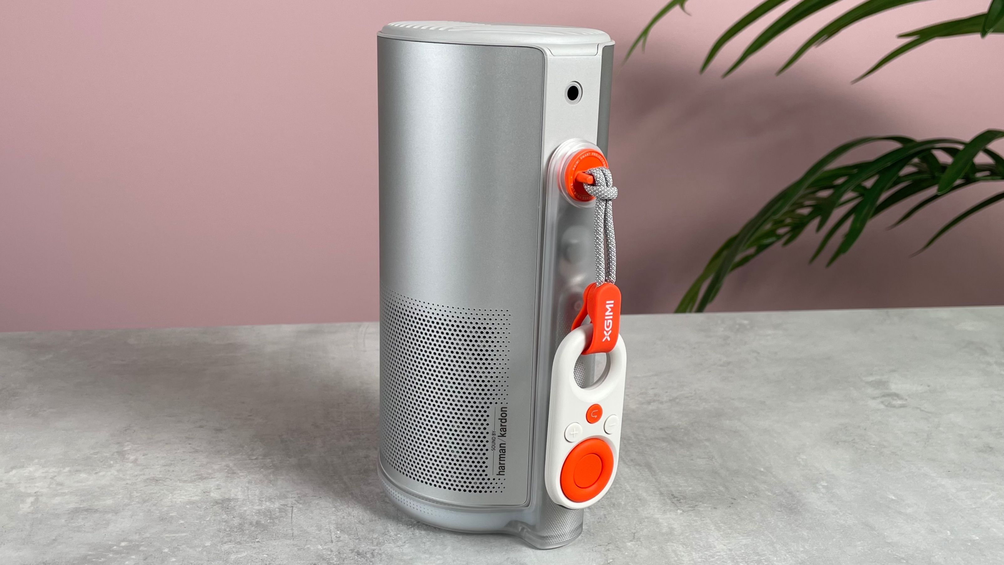 The XGIMI Mogo 4 is fully closed. It&#039;s mini remote is hanging from the side of the stand.