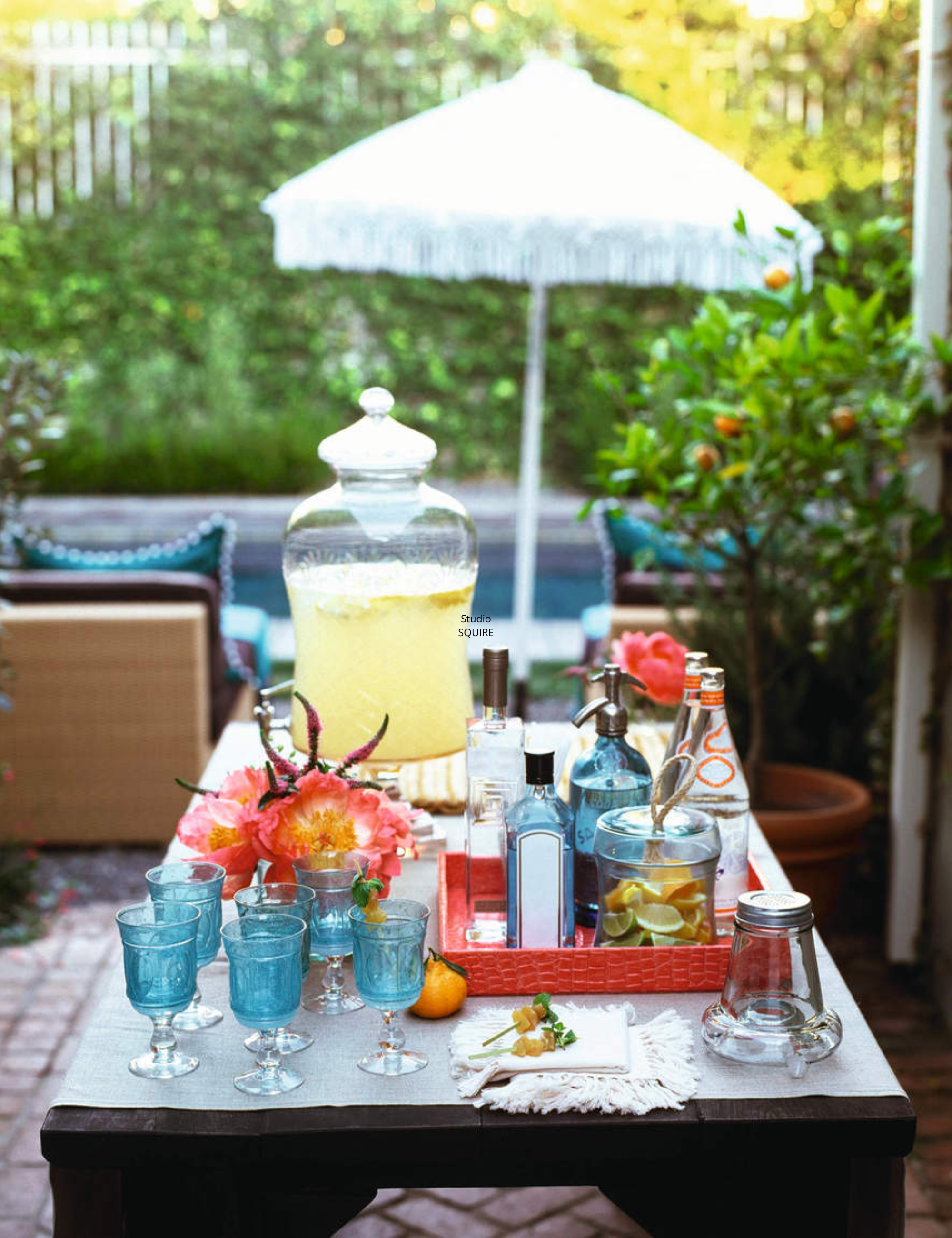 Outdoor drinks station, featuring a lemonade dispenser alongside vibrant blue glassware