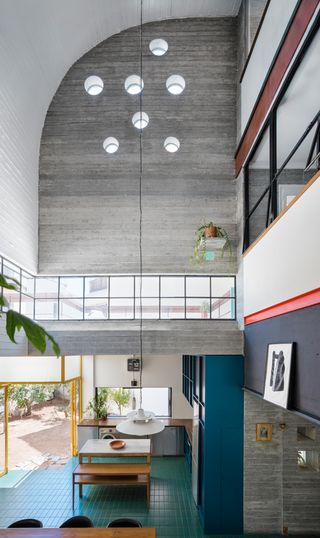 Petralona House - Raw and painted concrete walls contrast with bold hits of colour
