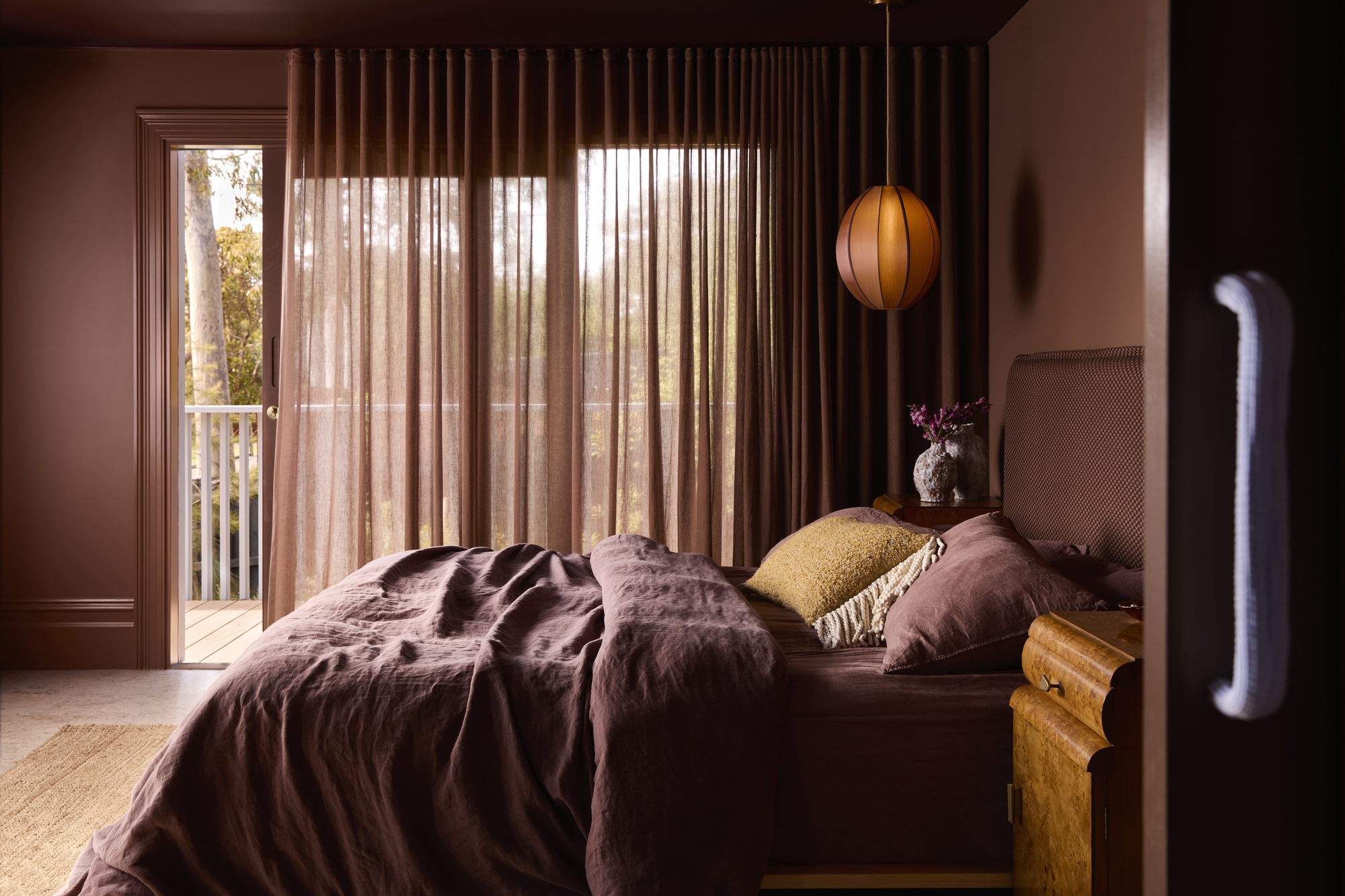 a burgundy bedroom with a sheer curtain
