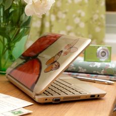 wooden table with laptop and flower vase