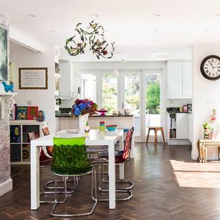 dinning area with white wall wooden floor white dinning table and chairs