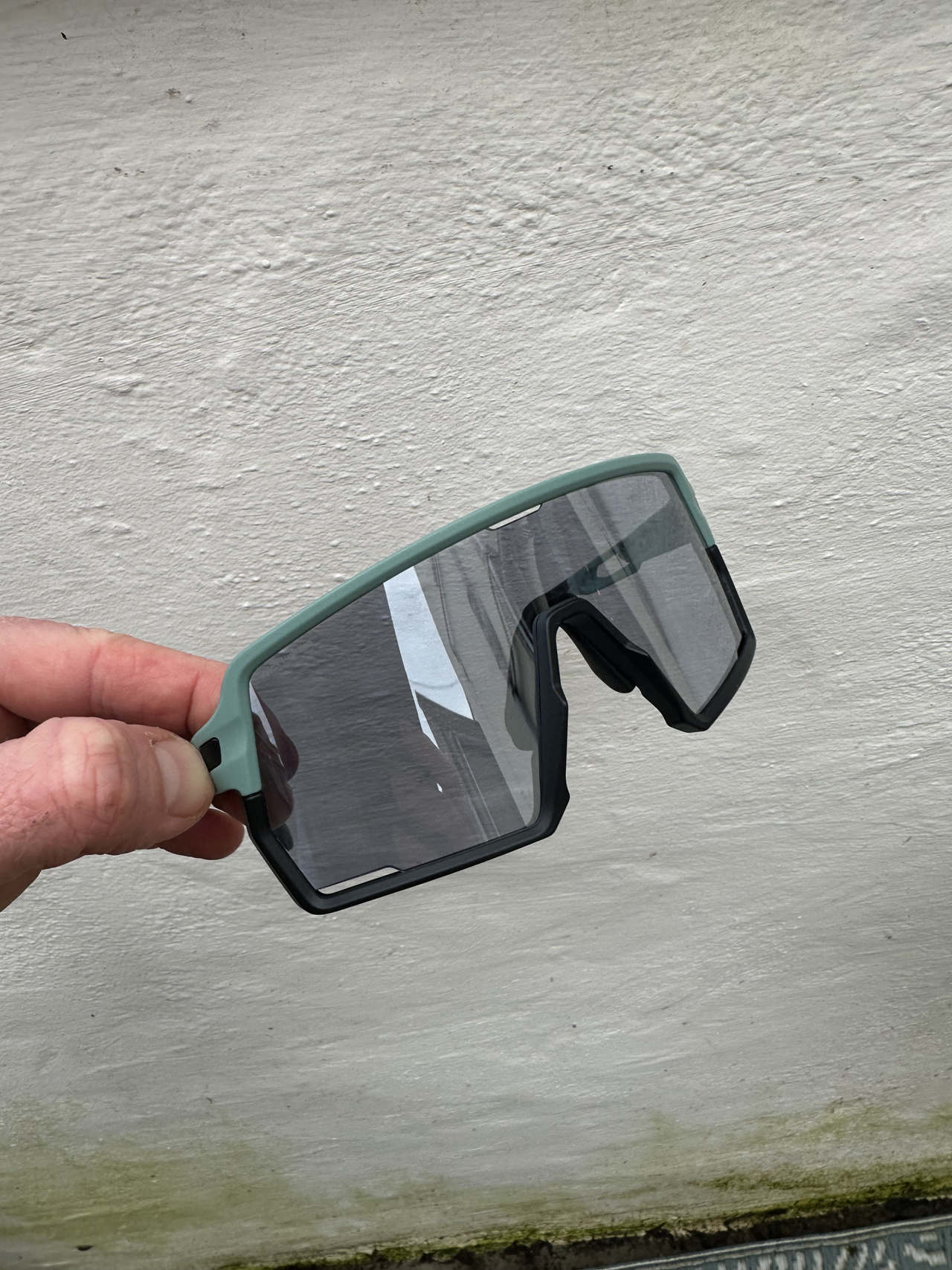 Sunglasses against a white wall