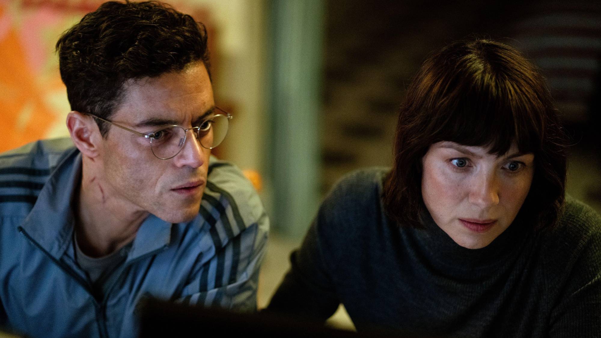 (L-R) Rami Malek as Charles "Charlie" Heller and Caitríona Balfe as Inquiline in "The Amateur"