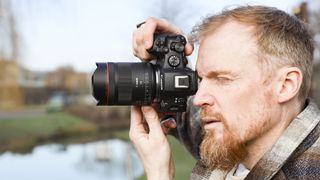 Canon RF 14mm F1.4L VCM lens in photographer Tim Coleman's hands, attached to an EOS R5 mark II