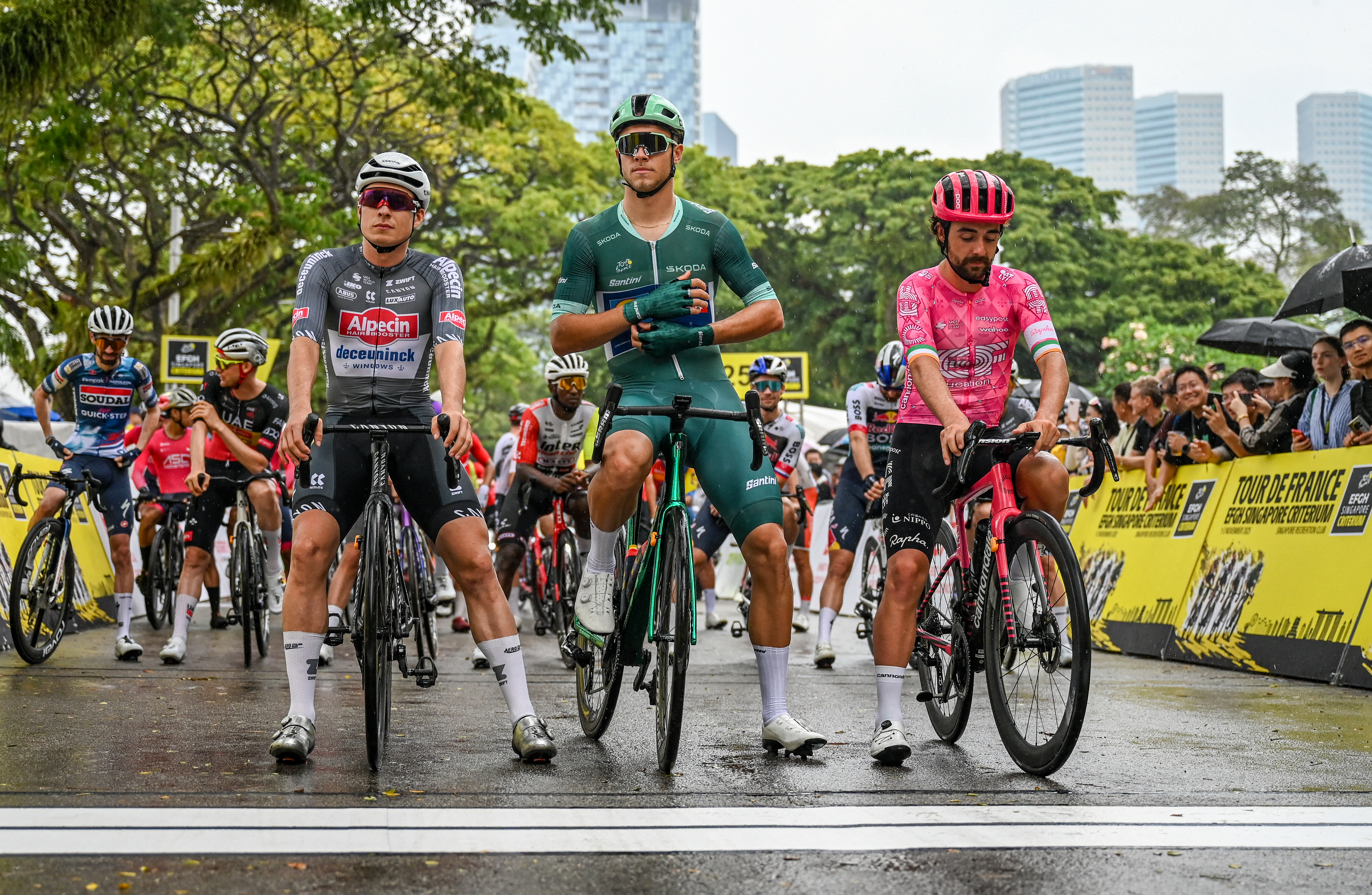 (De izquierda a derecha) Jasper Philipsen, el ciclista belga del equipo Alpecin, Jonathan Milan, el ciclista italiano del equipo Trek, y Ben Healy, el ciclista irlandés del equipo EF Education, EasyPost, esperan el inicio de la cuarta carrera del Criterium du Tour de Francia en Singapur, el 2 de noviembre de 2025. (Foto de Roslan RAHMAN / AFP)