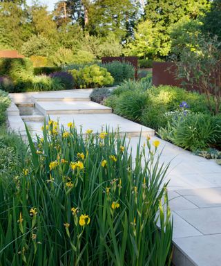 garden path running alongside a rill with planting