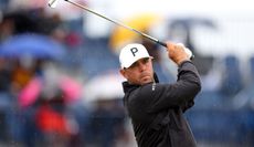 Gary Woodland strikes an iron shot off the tee in the rain at The Open Championship