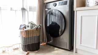 a basket of laundry next to washer-dryer in a home - washer-dryer not drying feature