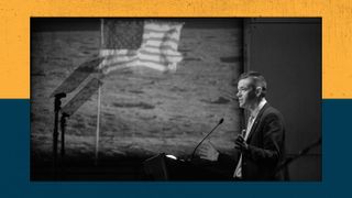 A man stands in front of a lectern with a projection of a U.S. flag on the moon appears in the background.
