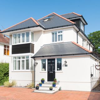 Exterior of a detached white rendered house with grey tiled roof