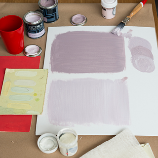 white paper can of purple paint and wooden paint brush