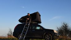 Camper sitting in the doorway of the TentBox Go