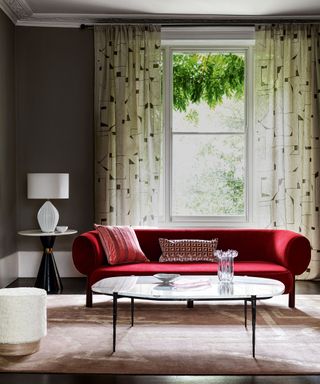red velvet sofa in living room with table lamp and oval coffee table