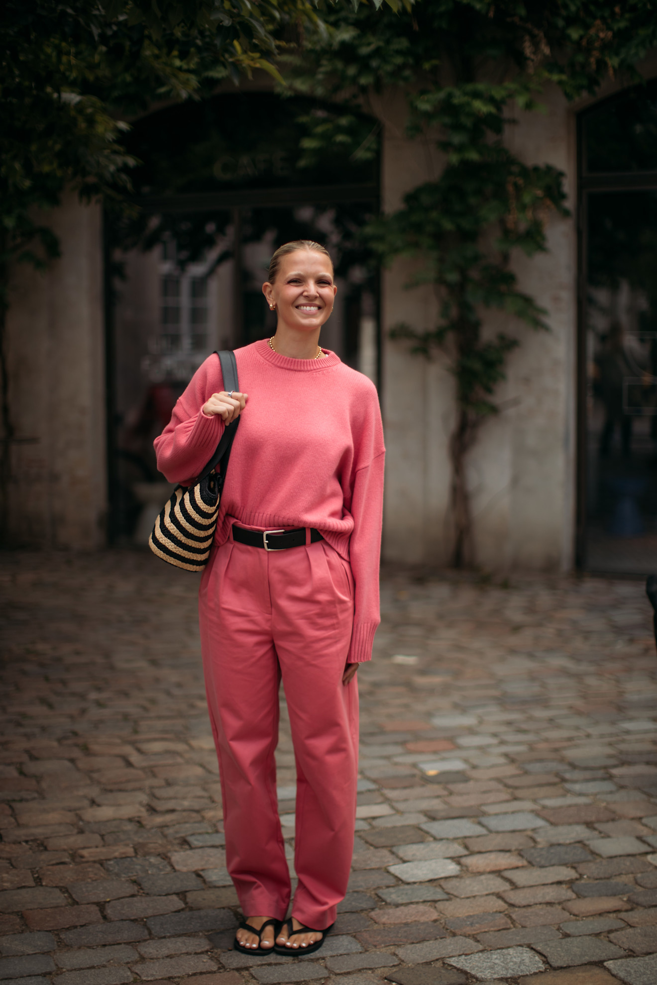 a guest at Copenhagen Fashion Week wearing salmon pink and flip flops