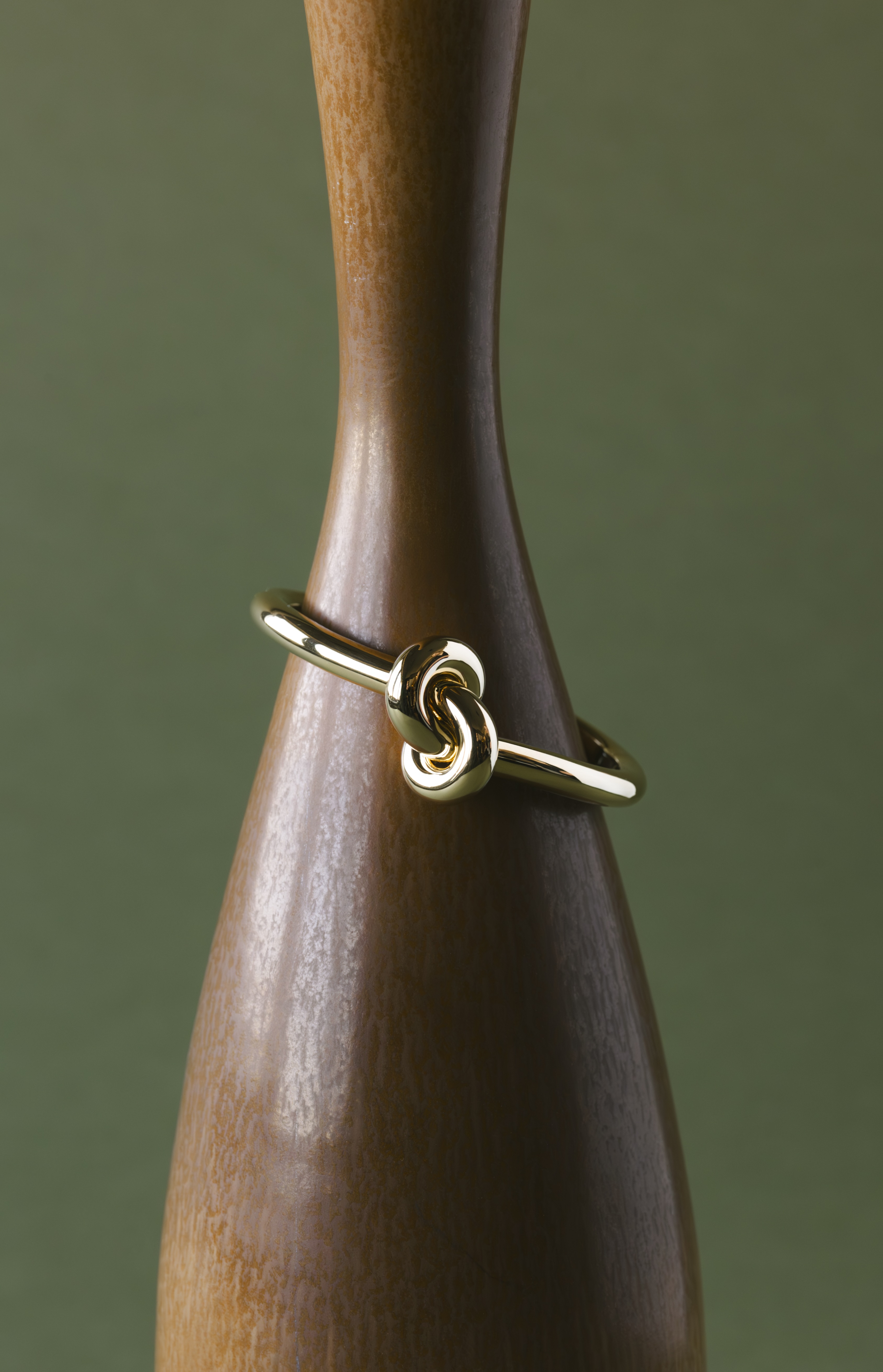 ceramics and jewellery against green and brown backgrounds