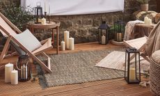 decking with outdoor rug and cushions and deck chairs 