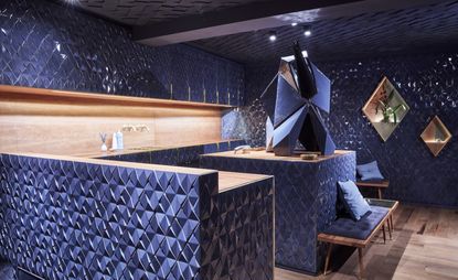 Bonechina interior with wooden bar lined with unevenly jointed blue and anthracite diamond cut tiles