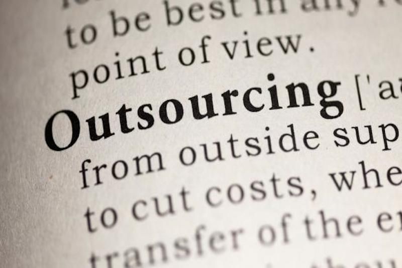 The word &amp;#039;outsourcing&amp;#039; in bold on piece of paper