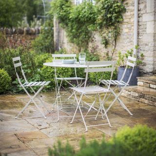 Patio with white metal table and four matching chairs