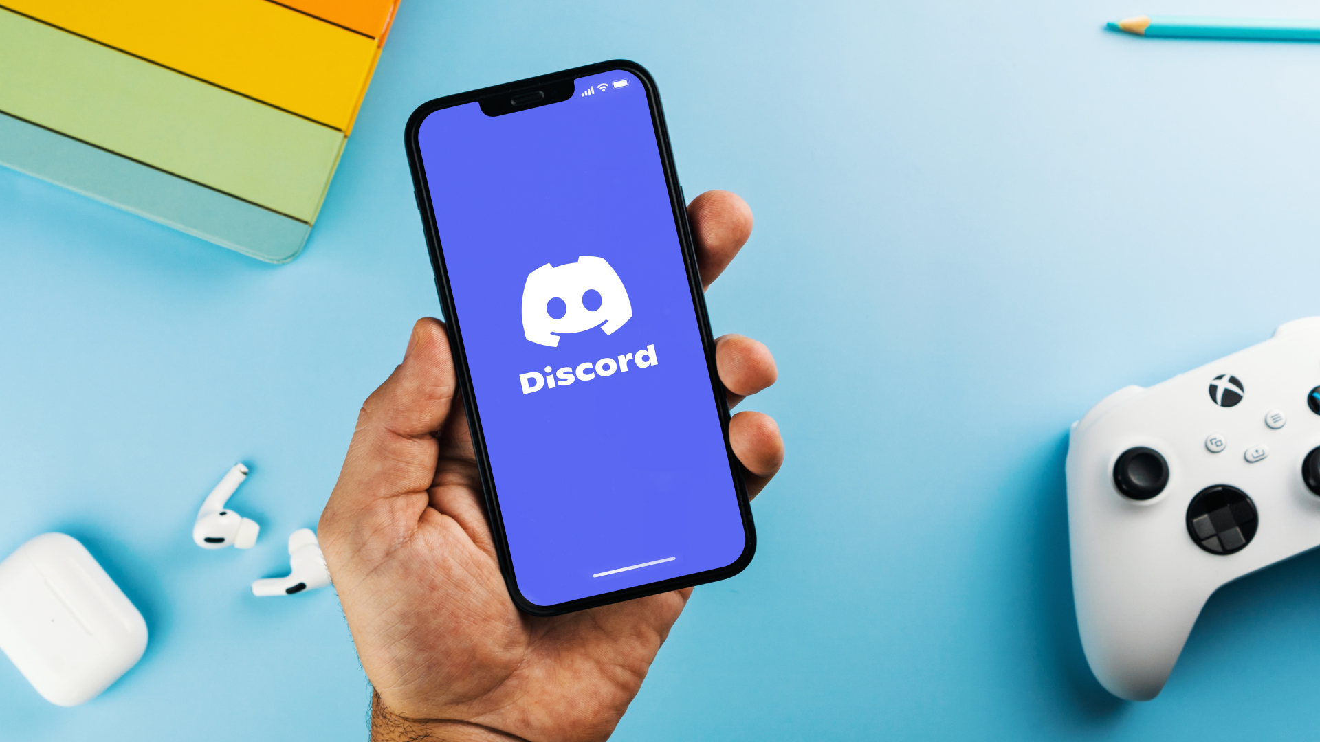 Discord logo on the phone next to the Xbox console