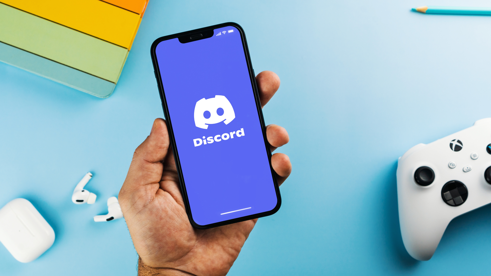 Logo Discord na telefonie obok konsoli Xbox