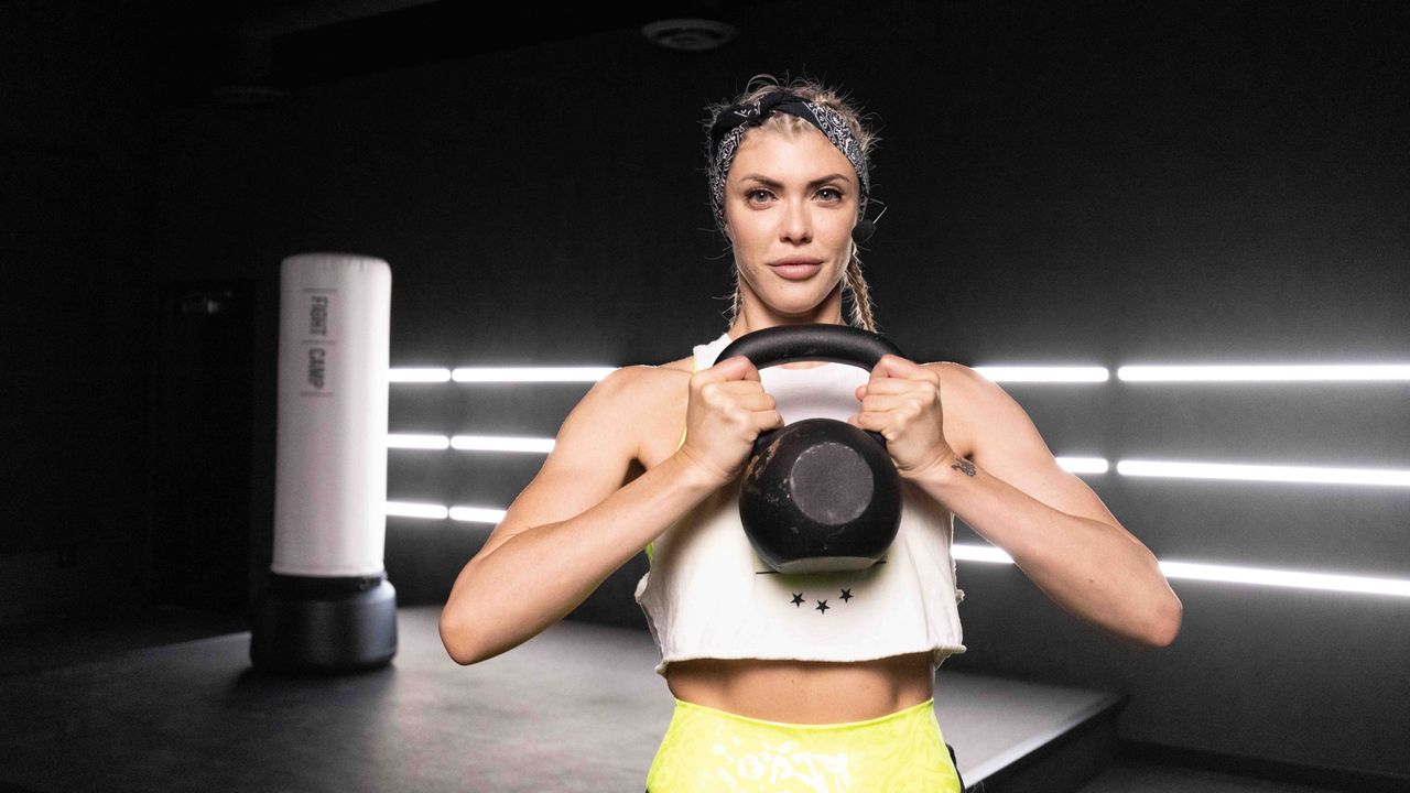 FightCamp Trainer Shanie SMASH holding a kettlebell in the FightCamp studio